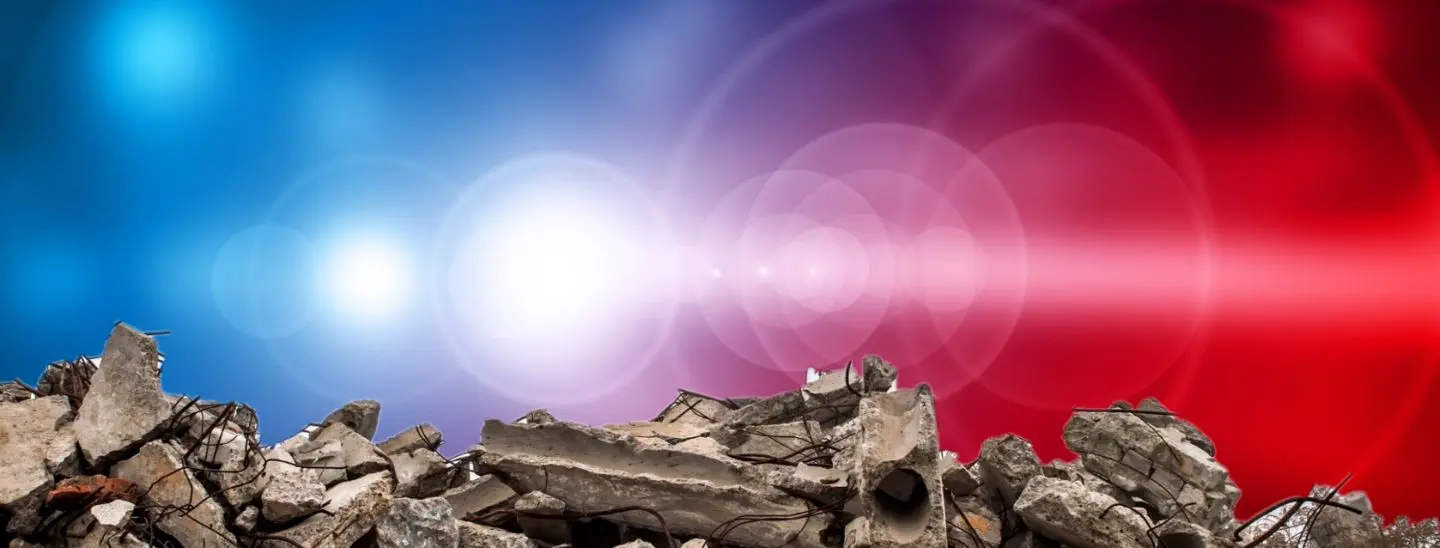 Red and blue sirens flash above a pile of rubble.