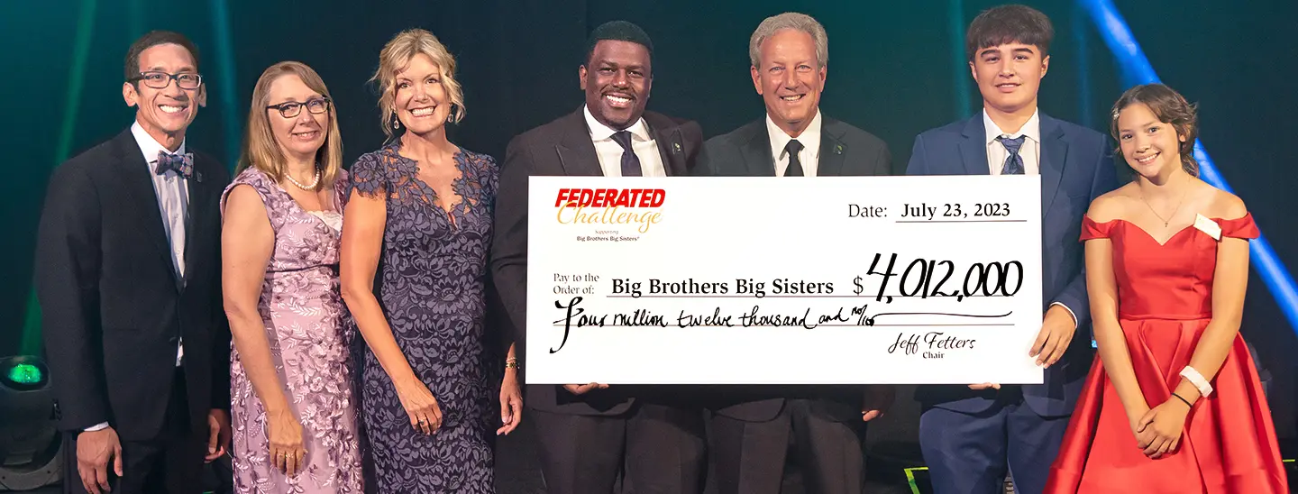 The 2023 Federated Challenge® raises a record-breaking $4,012,000 for Big Brothers Big Sisters® | Presenters holding $4,012,000 check at the Federated Challenge Gala. (from left to right): Big Brothers Big Sisters Twin Cities CEO Patrick Sukhum; Big Brothers Big Sisters of Central Minnesota Executive Director Jackie Johnson; Big Brothers Big Sisters of Southern Minnesota Executive Director Michelle Redman; Big Brothers Big Sisters of America President and CEO Artis Stevens; Federated Challenge Chair Jeff Fetters; Federated Challenge Co-Host and Little Isaiah; and Federated Challenge Co-Host and Little Delaney.
